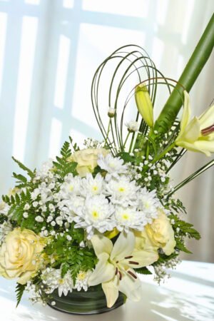 arreglo floral elegante con lirios blancos rosas crema y flores blancas en base moderna a domicilio en Santiago