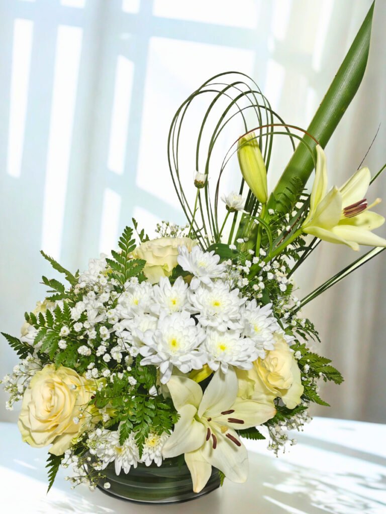 arreglo floral elegante con lirios blancos rosas crema y flores blancas en base moderna a domicilio en Santiago