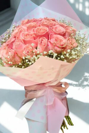 ramo de 24 rosas rosadas con gypsophila envuelto en papel elegante a domicilio en Santiago Chile