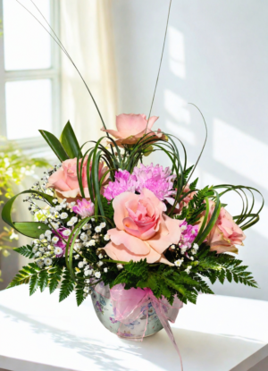 arreglo floral rosado con rosas y flores mixtas en base decorativa elegante con despacho a domicilio
