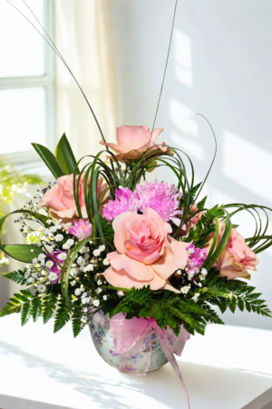 arreglo floral rosado con rosas y flores mixtas en base decorativa elegante con despacho a domicilio