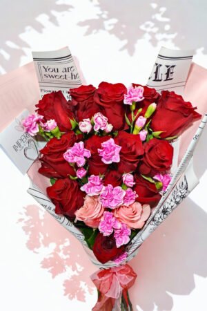 Ramo Promesa de Amor con 15 rosas premium, 13 rosas rojas y 2 rosas rosadas, acompañado de 8 varas de mini claveles y elegante papel coreano.