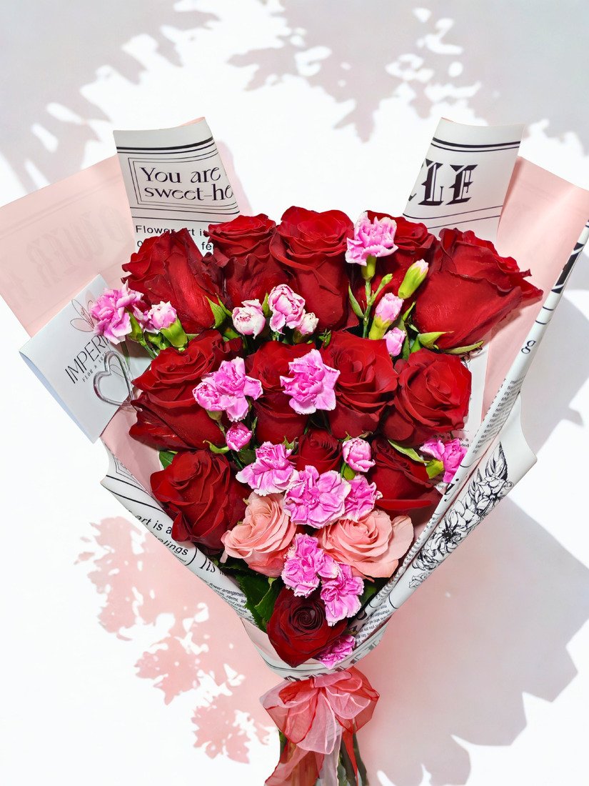 Ramo Promesa de Amor con 15 rosas premium, 13 rosas rojas y 2 rosas rosadas, acompañado de 8 varas de mini claveles y elegante papel coreano.