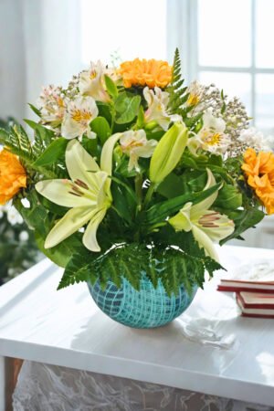Pecera de lirios y girasoles con flores frescas en tonos amarillos y blancos